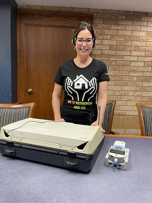 Juliana in front of hearing test and verification machine