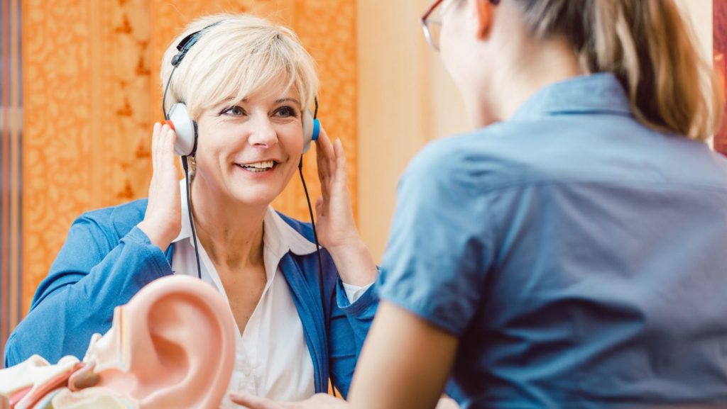 Older woman receiving a hearing assessment, illustrating hearing screening vs hearing test.